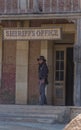 Live performance scenes, sheriff cowboy looking outside at the sheriff office building, on Oasys - Mini Hollywood, Spanish Western