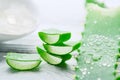 Aloe Vera gel closeup on white wooden background. Organic sliced aloevera leaf and gel, natural organic cosmetic ingredients