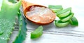 Aloe Vera gel closeup on white wooden background. Organic sliced aloevera leaf and gel, natural organic cosmetic ingredients