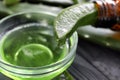 Aloe vera juice dripping from green leaf into bowl, closeup Royalty Free Stock Photo