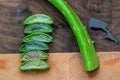 Aloe Vera leaf cut and sliced and stacked on wooden butcher block