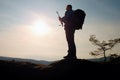 Alone adult man backpacker at sunrise at open view on mountain peak