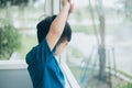 Asian boy looking out of the window, waiting for someone Royalty Free Stock Photo