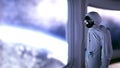 Alone astronaut in futuristic interior. Sci fi room view of the earth. 3d rendering. Royalty Free Stock Photo
