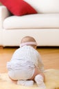 Alone baby girl sit down on fur at hardwood floor