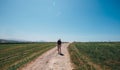 Alone backpacker traveler walks on contryside road in sultry aft Royalty Free Stock Photo