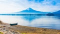 alone boat mooring on ground at side of lake kawaguchi on morning time with fuji mountain background Royalty Free Stock Photo