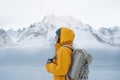 Alone brave woman traveler with backpack looking away to winter mountains