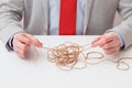 Alone businessman try to unwinds tangled thread ball like puzzle out situation. Conceptual photo Royalty Free Stock Photo