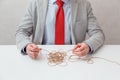 Alone businessman try to unwinds tangled thread ball like puzzle out situation. Conceptual photo