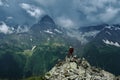 Alone hiker man with backpack and helmet against the gloomy mountain peak landscape with thunder cloudy sky Royalty Free Stock Photo