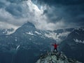 Alone hiker man in red jacket against the gloomy mountain top landscape with thunder cloudy sky Royalty Free Stock Photo