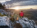 Alone hiker photographer in warm red jacket stand on peak