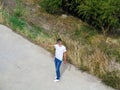 Alone hitchhiking man on the road raised his hand to stop auto. A deserted country road with grass and greens on the side of the Royalty Free Stock Photo