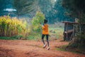 Alone Kenyan woman trains to run in Africa. A female marathon runner runs on red soil in the city of Iten, home of Champions
