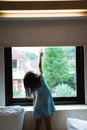 Alone little girl reaching window curtain Royalty Free Stock Photo