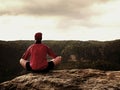 Alone man is doing Yoga pose on the rocks peak within misty morning. Middle-aged man practicing yoga Royalty Free Stock Photo