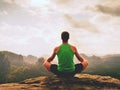 Alone man is doing Yoga pose on the rocks peak within misty morning. Middle-aged man practicing yoga Royalty Free Stock Photo