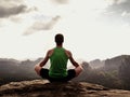 Alone man is doing Yoga pose on the rocks peak within misty morning. Middle-aged man practicing yoga Royalty Free Stock Photo