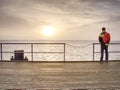 Alone man on pier look over handrail into water Royalty Free Stock Photo