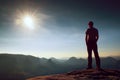 Alone man in red cap on peak of sharp peak in rock empires park and watching over the misty and foggy morning valley to Sun. Beaut Royalty Free Stock Photo