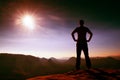 Alone man in red cap on peak of sharp peak in rock empires park and watching over the misty and foggy morning valley to Sun. Beaut Royalty Free Stock Photo