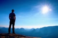 Alone man in red cap on peak of sharp peak in rock empires park and watching over the misty and foggy morning valley to Sun. Beaut Royalty Free Stock Photo