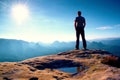 Alone man in red cap on peak of sharp peak in rock empires park and watching over the misty and foggy morning valley to Sun. Beaut Royalty Free Stock Photo