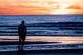 Alone man silueta looking at the sea at dusk but blue and red sky in the background Royalty Free Stock Photo