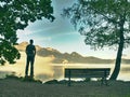 Alone man sits on bench beside an azure mountain lake. Man relax Royalty Free Stock Photo