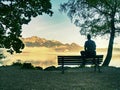 Alone man sits on bench beside an azure mountain lake. Man relax Royalty Free Stock Photo