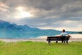 Alone man sits on bench beside an azure mountain lake. Man relax Royalty Free Stock Photo