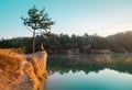 Alone man sitting alone at sunset near the sea, relaxing and thinking about the meaning of life. Hiker on top of a Royalty Free Stock Photo