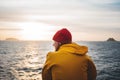 Alone man traveling on ship and looking at sunset sea and foggy mountain on skyline