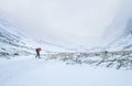 Alone mountaineer has a solo winter Ben Nevis 1345m summit approaching in high mountains on windy snowy weather at Highlands of