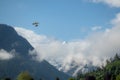 Alone paraglider flying in the blue sky with clouds above mountains Royalty Free Stock Photo