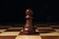 Alone pawn on chess desk against dark background