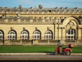 Alone red vintage scooter on background of the building of classical architecture