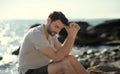 Alone sad man sitting on a beach Royalty Free Stock Photo