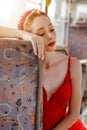 Alone and sad young beautiful woman is looking toughtful while she sit in a bus and traveling.