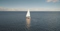 Alone sail yacht reflect at ocean water aerial. Racing sailboat at open sea. Luxury vessel at summer Royalty Free Stock Photo