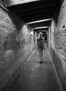 Alone woman running in dark tunnel