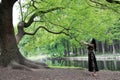 Alone woman under a big blossom tree . Enjoying the nature