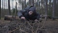 Alone young boy kindling bonfire with dry twigs and leaves.