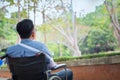 Alone young disabled man on wheelchair in the park, Patient is r Royalty Free Stock Photo