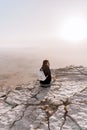 Alone young girl with backpack in israel negev desert admires the view of sunrise. Young female person stands on the edge