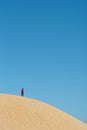Alone young male asian standing on top of sand dune.