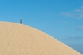 Alone young male asian standing on top of sand dune.