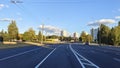 Along the city street there are residential houses with balconies, trees, lampposts and parked cars. Nearby is a paved roadway wit Royalty Free Stock Photo