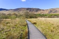 Along a curved boardwalk at Derwent Water towards Maiden Moor and Cat Bells fell Royalty Free Stock Photo
